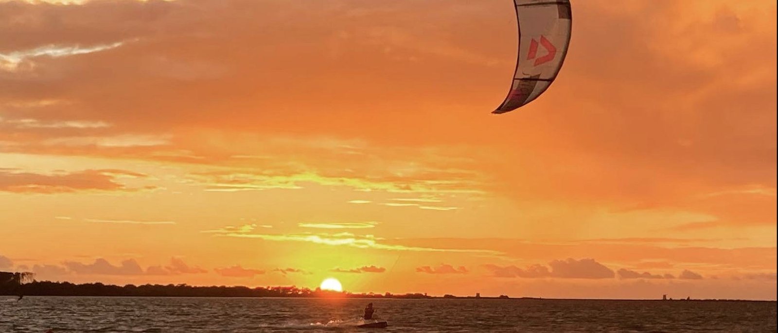 Session de kitesurf au coucher du soleil
